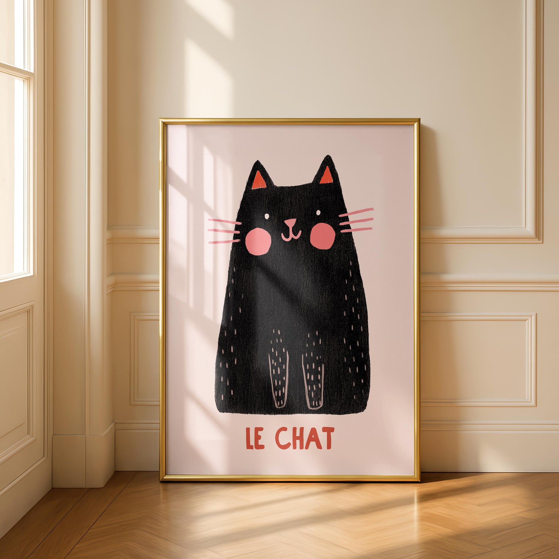 A framed print of a black cat with pink cheeks and ears, and the words "LE CHAT" in red, hangs on a light-colored wall.
