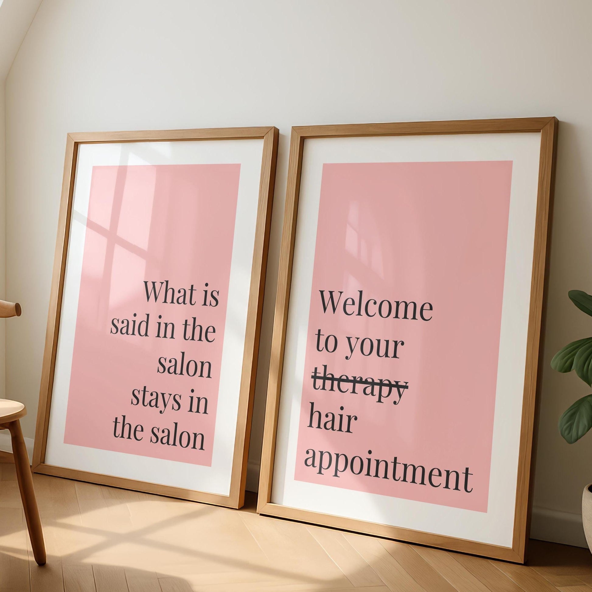 Two framed prints with pink backgrounds and black text lean against a white wall; the left reads "What is said in the salon stays in the salon," and the right reads "Welcome to your therapy hair appointment."